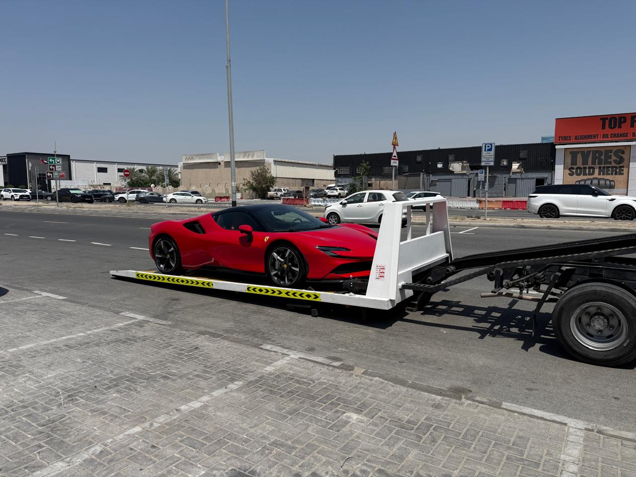 Ferrari SF90 loaded on a flatbed recovery truck in Dubai
